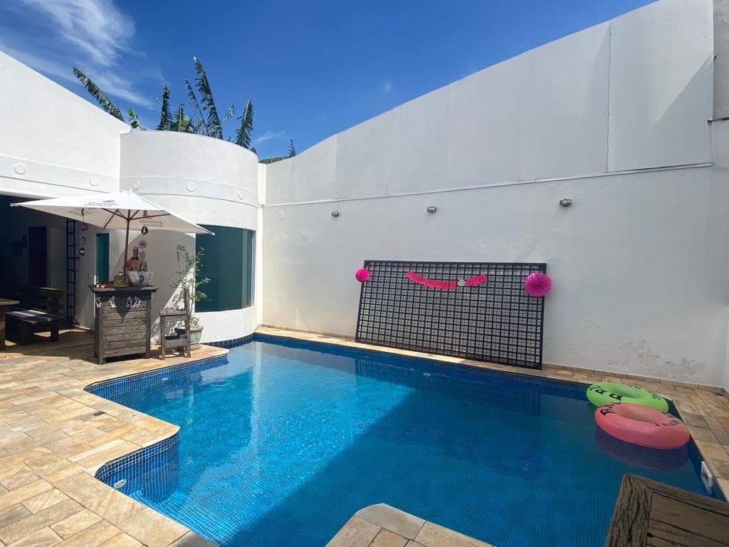 Área de piscina moderna com espreguiçadeiras e ambiente relaxante