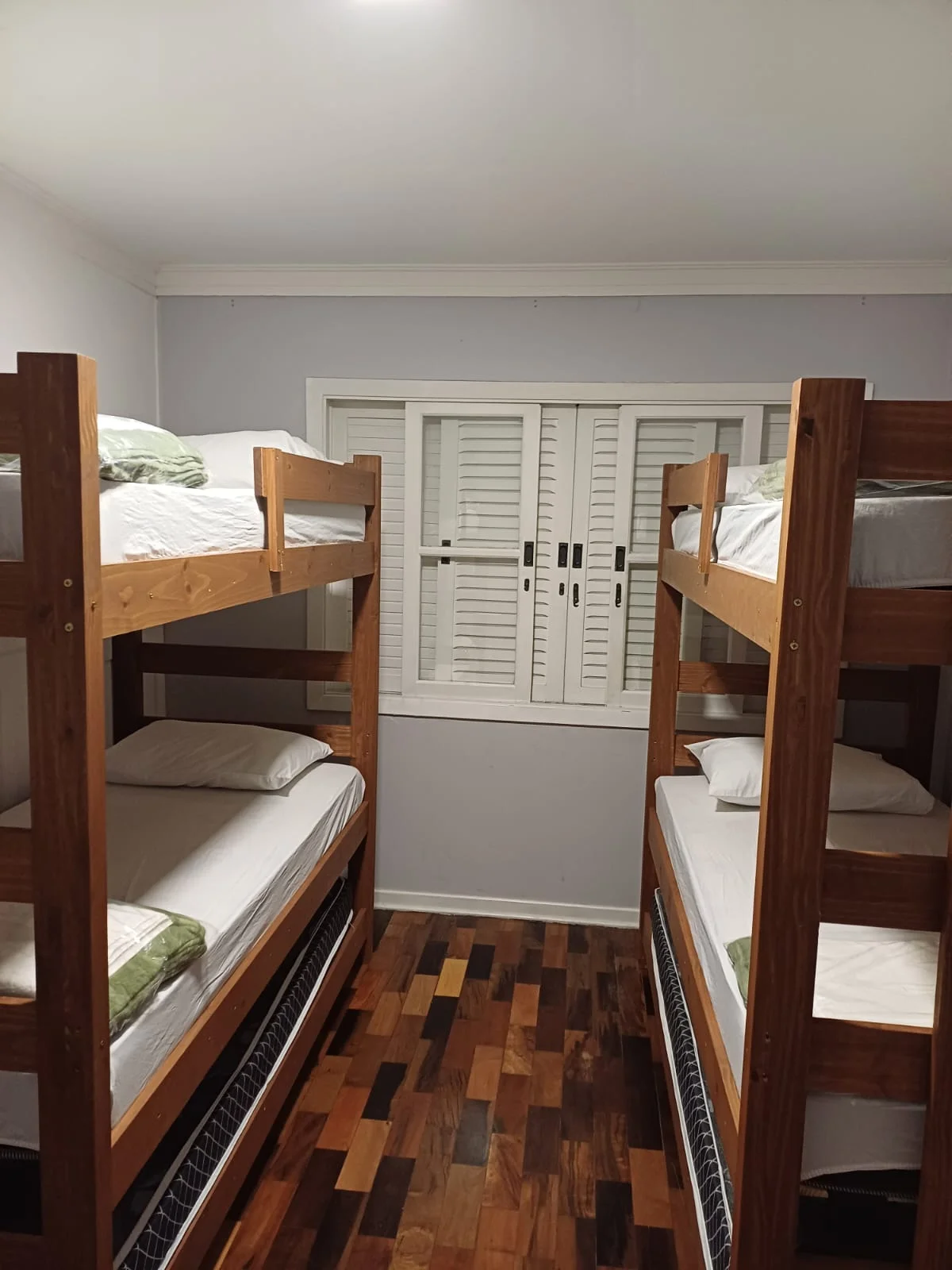 Dormitório compartilhado com beliches de madeira